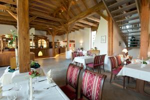 uma sala de jantar com mesas brancas e cadeiras vermelhas em Hotel Kloster Nimbschen 4 Sterne em Grimma