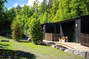 ein schwarzes Gebäude mit einer Holzterrasse im Hof in der Unterkunft Juliusskogen 