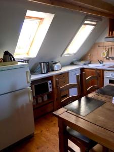 Il comprend une cuisine avec des lucarnes, une table et un réfrigérateur. dans l'établissement Ferienwohnung am Papensee, à Hohen Sprenz