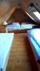 two beds in a small room with wooden floors at Ferienwohnung am Papensee in Hohen Sprenz