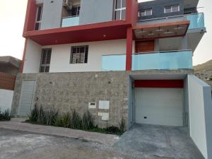 a apartment building with a garage in front of it at Helton´s Residence in Praia