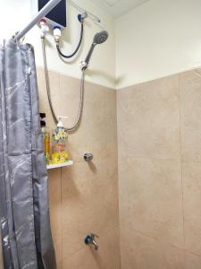 eine Dusche im Bad mit Duschvorhang in der Unterkunft 1 Bedroom Deluxe in Parañaque in Manila