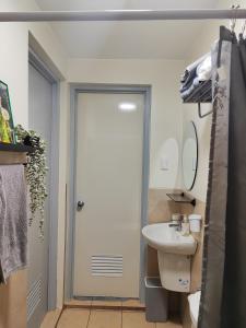 ein Bad mit einer Tür, die zu einem Waschbecken führt in der Unterkunft 1 Bedroom Deluxe in Parañaque in Manila
