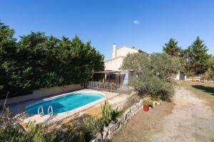a swimming pool in front of a house at Mas Provençal de 120m2 en Camargue, Avec Piscine et Parking inclus, Idéal pour des vacances in Arles