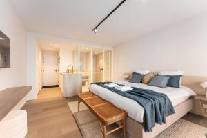 een slaapkamer met een groot bed en een badkamer bij Seaflower - Romantische luxe studio met zeezicht in De Panne