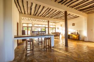 a kitchen and dining room with a table and stools at Milele Villas in Potoa