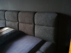 un divano grigio nell'angolo di una stanza di THE BLACKTAGON Cozy Room a Francoforte sul Meno