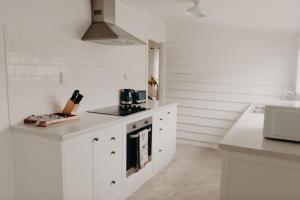 a kitchen with white cabinets and a stove top oven at Balnagown in Albany