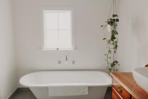 a white bath tub in a bathroom with a window at Balnagown in Albany +13 photos