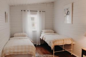 two beds in a room with white walls at Balnagown in Albany