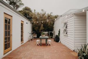 a patio with a table and chairs next to a building at Balnagown in Albany