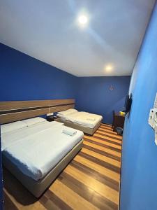 2 camas en una habitación con paredes azules en Sky View Hotel Dengkil PUTRAJAYA, en Kampung Dengkil