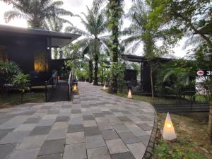 a walkway in front of a building with palm trees at X Park Iskandar Puteri in Nusajaya