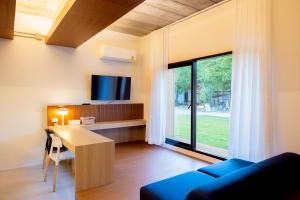 ein Wohnzimmer mit einem Schreibtisch und einem TV in der Unterkunft Karpenter Lampang in Lampang