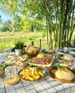 uma mesa com muitos pratos de comida em DeAsmarra Homestay em Tanjung Piandang