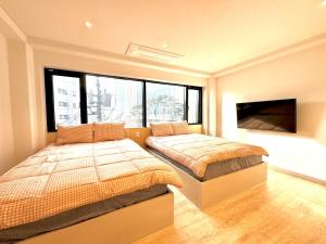 a bedroom with two beds and a flat screen tv at Namsan Forest in Myeongdong in Seoul