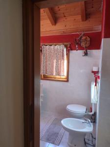a bathroom with a toilet and a sink and a window at San Carlo in Chiavenna