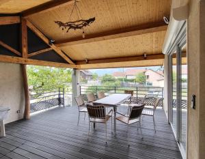 a patio with a table and chairs on a deck at 'Games of Home' - logement T3 in Saint-Égrève