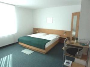 sypialnia z łóżkiem, stołem i lustrem w obiekcie Appartementhaus Anne w mieście Binz