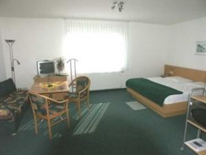 a bedroom with a bed and a desk with a computer at Appartementhaus Anne in Binz +7 photos