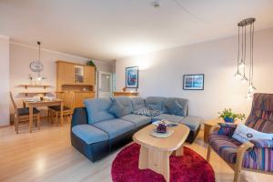 ein Wohnzimmer mit einem blauen Sofa und einem Tisch in der Unterkunft Haus Seydlitz FV 13 in Binz
