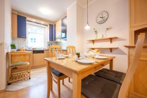 eine Küche und ein Esszimmer mit einem Holztisch und Stühlen in der Unterkunft Haus Seydlitz FV 13 in Binz