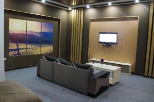 un soggiorno con un divano e una TV di Paradise Hotel a Saryaghash