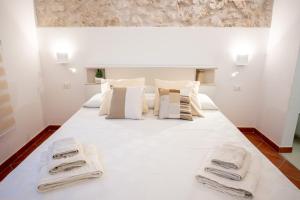 - une chambre avec un lit blanc et des serviettes dans l'établissement Casa ORCHIDEA D'ORO, à Syracuse