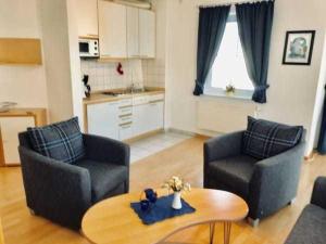 a living room with two chairs and a table at Haus Volksbank FV in Binz