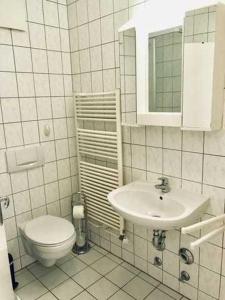 a white bathroom with a toilet and a sink at Haus Volksbank FV in Binz