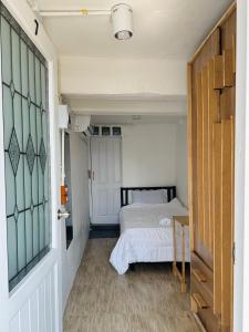 a small bedroom with a bed and a door at Chubby 9 Room 7 in Bangkok