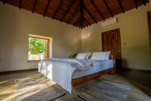una camera da letto con un grande letto bianco con una finestra di Omkara Rekawa a Tangalle Altre 37 foto