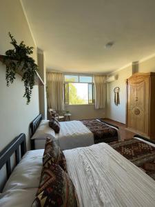 a hotel room with three beds and a window at La Casa Budget in Marsa Alam City