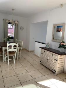 uma cozinha e sala de jantar com uma mesa e um espelho em Palm Villa em Puerto del Carmen