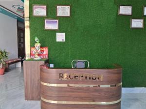 a reception desk in a green wall with a reception counter at HOLIDAYY INN in Prayagraj