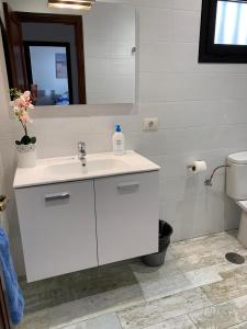 uma casa de banho com um lavatório branco e um espelho. em Palm Villa em Puerto del Carmen