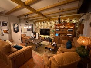 a living room with couches and a tv at Cortijo Rodeo. Alojamiento Rural in Carcabuey