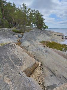 um grupo de rochas na costa de uma praia em Topsala Seaside em Houtskari