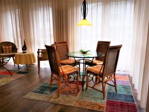 a dining room with a glass table and chairs at Villa Maria 10 in Binz