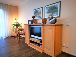 a living room with a television on a wooden cabinet at Villa Maria 10 in Binz
