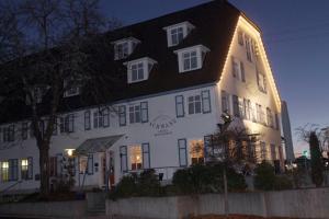 a white building with a black roof at night at Hotel Garni Schwane in Meßstetten