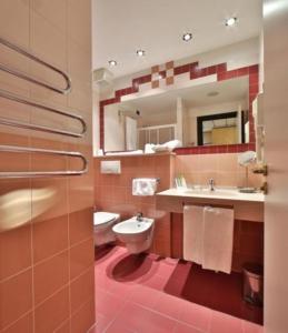 a bathroom with a toilet and a sink and a mirror at Best Western Hotel Solaf in Medolago