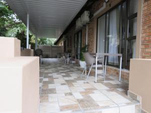 a patio with chairs and a table on a building at Die Stoep in Richards Bay
