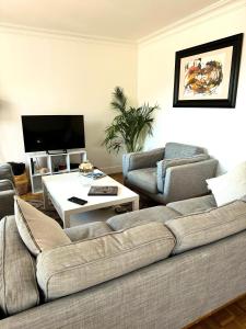 a living room with two couches and a table at Le Bergson - Appart 80m2, proche stade Olympique, entièrement rénovée et équipée, lumineux, WIFI, balcon, quartier calme, vue imprenable in Saint-Étienne