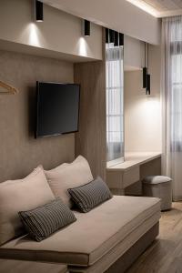Schlafzimmer mit einem Bett und einem Flachbild-TV an der Wand in der Unterkunft CASA DORINI in Chania