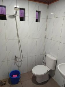 a bathroom with a toilet and a sink and a shower at Rammang-Rammang Cottage in Kasijala