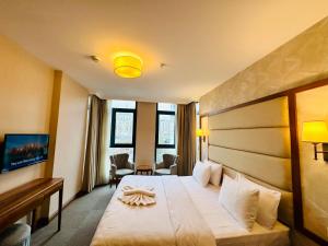 イスタンブールにあるIstanbul Midpoint Hotelの大きなベッドとデスクが備わるホテルルームです。