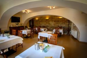 a restaurant with tables and chairs and a stone wall at Hotel U Krále in Jičín