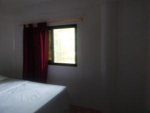 - une chambre avec un lit et une fenêtre dans l'établissement Kaye En Em Apartelle, à Puerto Galera