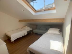 Zimmer im Dachgeschoss mit 2 Betten und einem Fenster in der Unterkunft Plage Monaco in Roquebrune-Cap-Martin
